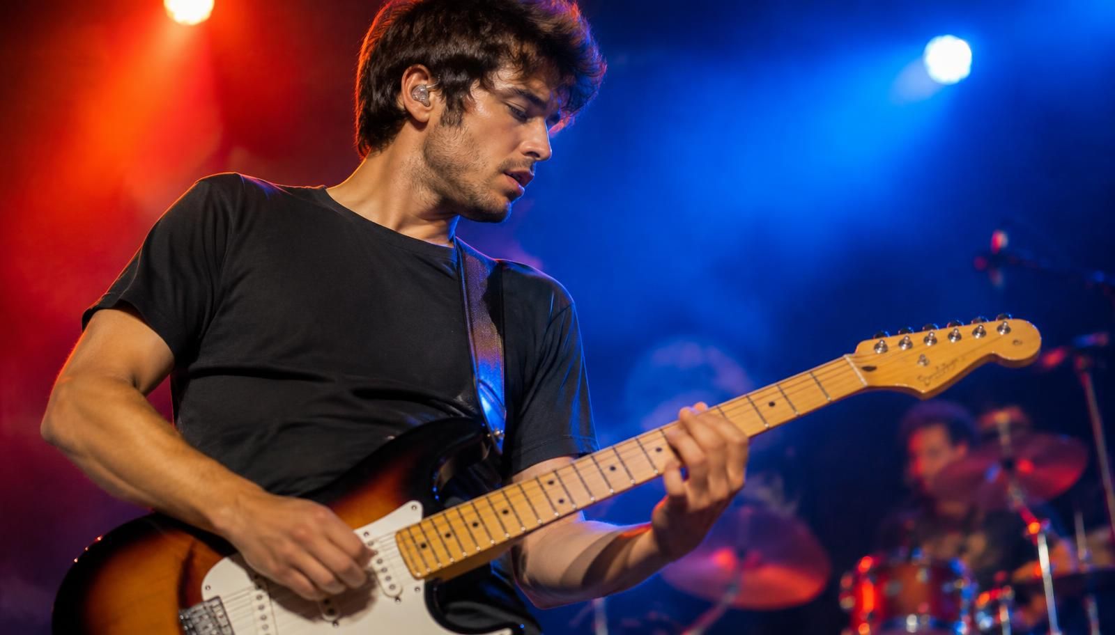 Gitarrist auf der Bühne mit Gehörschutz für Musiker