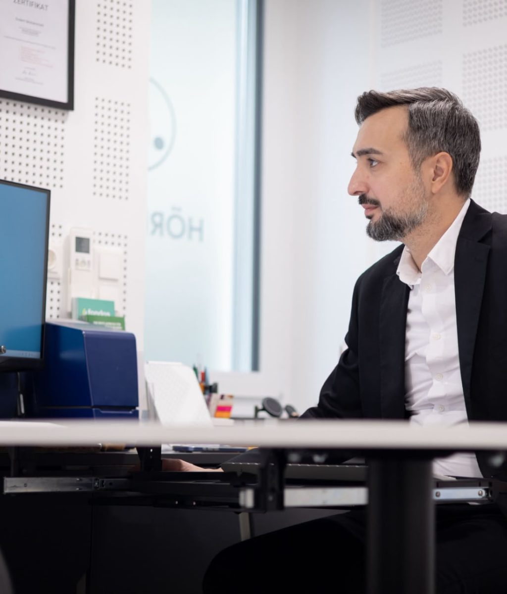 Hörgeräteexperte am Arbeitsplatz im Fachgeschäft in Wien 1040